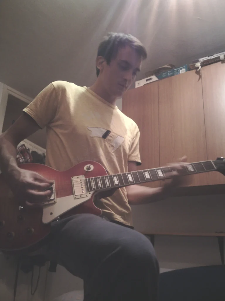 Filip Dorić playing electric guitar in his bedroom studio — the start of creating music for your digital journey and video soundtracks.