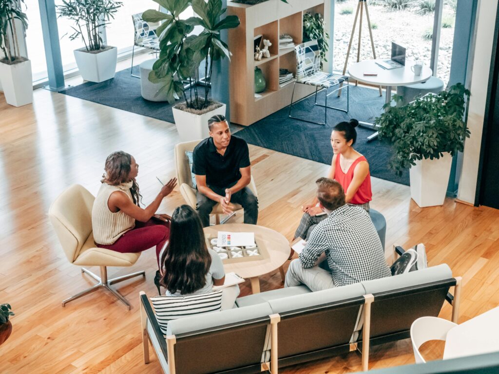 A diverse group of professionals sitting in a circle during a collaborative team meeting in a stylish office setting.