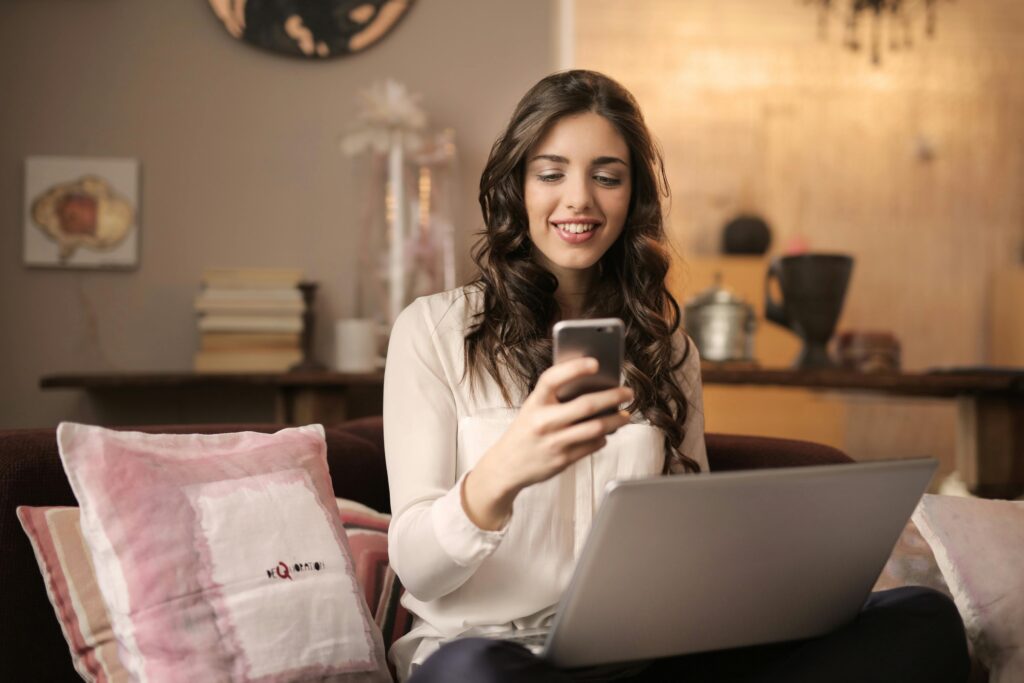 A young student smiling while watching funny cat videos on her phone