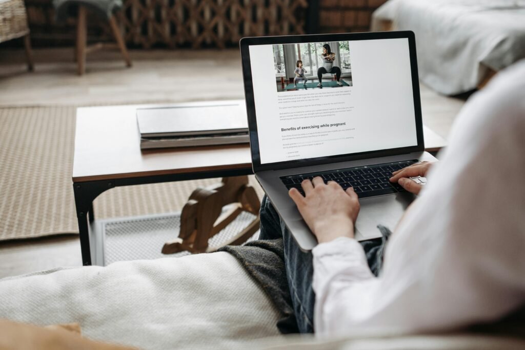 pexels-photo-7055876-7055876 Person working remotely on a laptop in a cozy home setting, emphasizing comfort and technology.